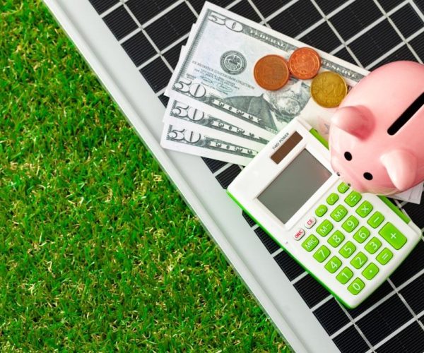 Solar panel model and piggy bank close up